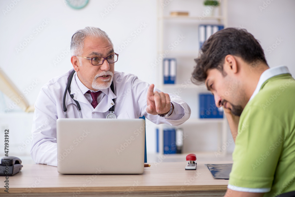 Young male patient visiting old male doctor Young male patient visiting old male doctor