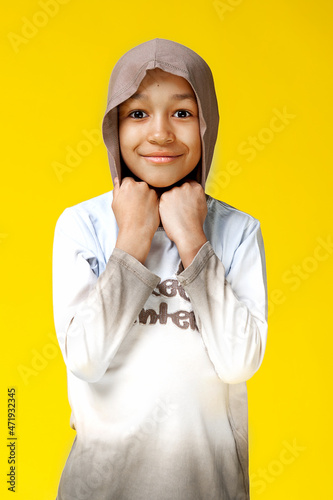 Funny mixed race kid boy posing on bright yellow background