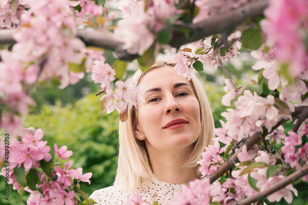 Young woman among the blossoming trees. Spring nature park or garden, flowering trees. Concept spring woman health Young woman among the blossoming trees. Spring nature park or garden, flowering trees. Concept spring woman health