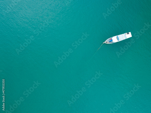 Aerial top view photo of traditional wooden fishing boat in tropical sea Phuket island Beautiful turquoise sea in summer day Copy space image for travel and tour