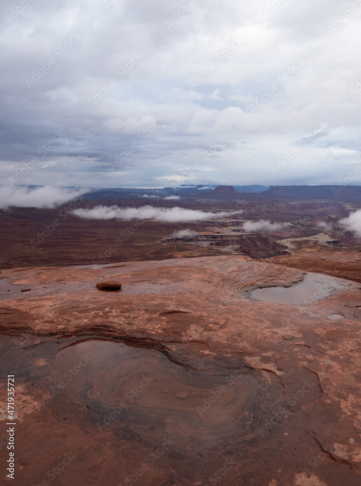 Water Puddles in Sandstone with Green River Canyon in the Island in the Sky District of Canyonlands National Park on a Rainy Day
