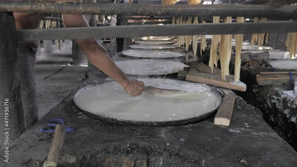 Tofu skin made from soybeans. workers skim up the foam forms on the liquid surface during the boiling of soy milk ( close up ) Tofu skin made from soybeans. workers skim up the foam forms on the liquid surface during the boiling of soy milk ( close up )