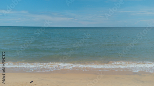 Aerial view of clear turquoise sea on sandy beach and ocean with waves.