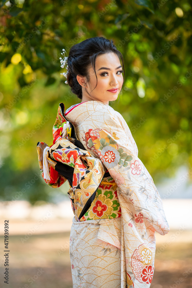 Portrait of smiling woman wearing kimono standing in park Portrait of smiling woman wearing kimono standing in park