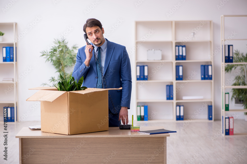 Young male employee in business relocation concept Young male employee in business relocation concept
