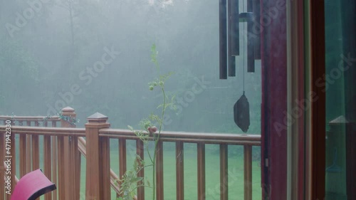 Rain On Porch With Windchimes and Tomato Plant photo