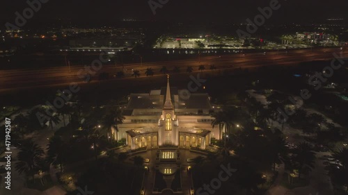 zoom out drone shot of latter-day saints church at night