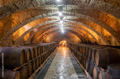 Old wooden barrels with wine in the ancient medieval cellars
