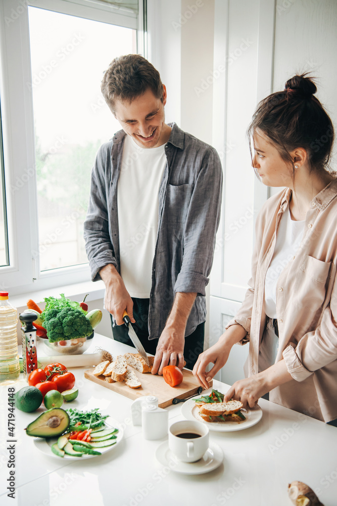 Man and woman are having fun together in the kitchen while making breakfast. Healthy meal. Family cooking. Healthy diet. Man and woman are having fun together in the kitchen while making breakfast. Healthy meal. Family cooking. Healthy diet.