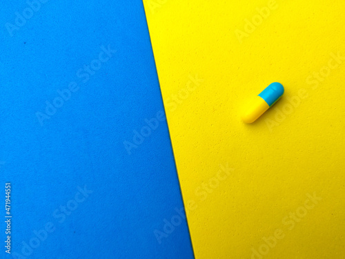 Piles of pills and capsules with copy space on colorful background.Selective focus.