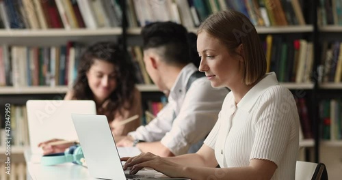 Wallpaper Mural Teen girl sit at table preparing for test exam with laptop, writes essay, text coursework use notebook at public or college library. Doing research or assignment. Gen Z, modern tech, education concept Torontodigital.ca