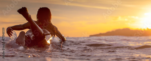Landscape image of Sunset scene with a girl on a surfboard