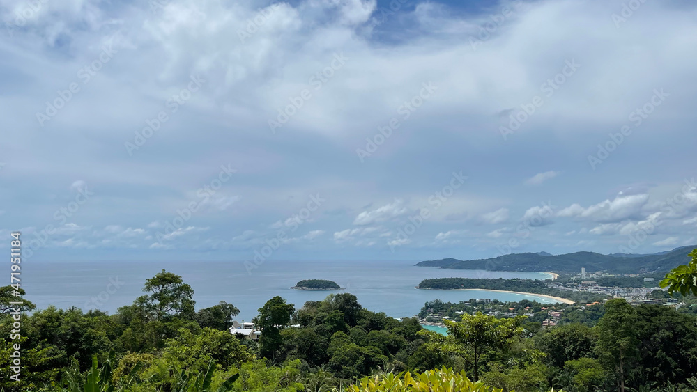 Phuket. Thailand. Tropical island. Reopening season 2022. Phuket sandbox tourism program. View from the Karon view point to the sea bay and green forest. Crones of trees.  Sky with beautiful clouds. 