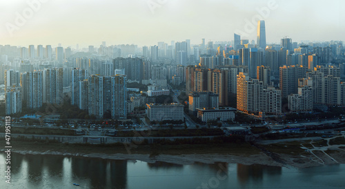 The city is in Chongqing, China. The river is called the Jialing River. At sunset, the city has warm sunlight afterglow