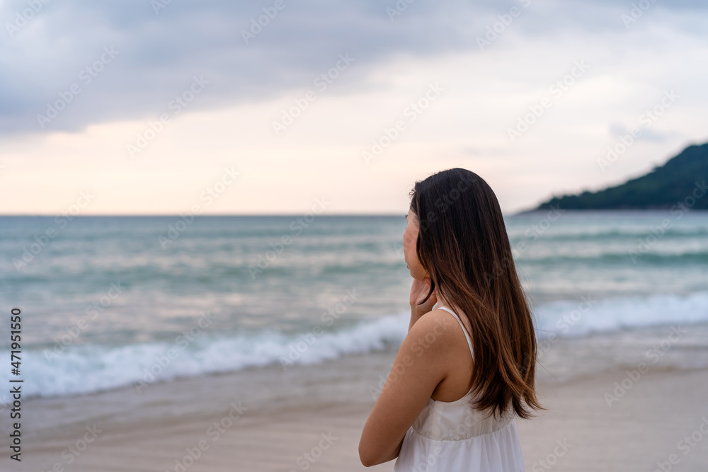 Young woman feeling lonely and sad looking at the sea on a gloomy day Young woman feeling lonely and sad looking at the sea on a gloomy day