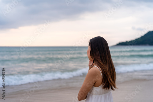 Young woman feeling lonely and sad looking at the sea on a gloomy day
