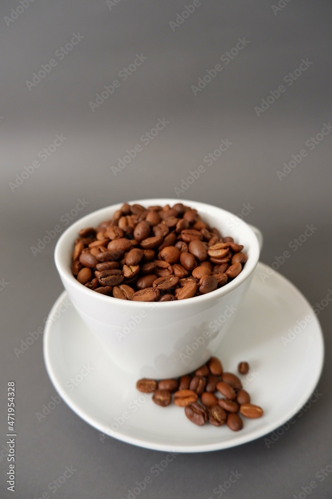 Coffee beans and cup & saucer on gray background. Cafe, Coffee, restaurant design elements. Coffee beans and cup & saucer on gray background. Cafe, Coffee, restaurant design elements.