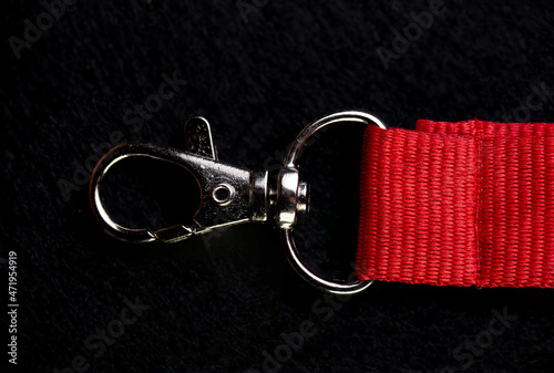 metal carabiner on a red ribbon on a black background photo