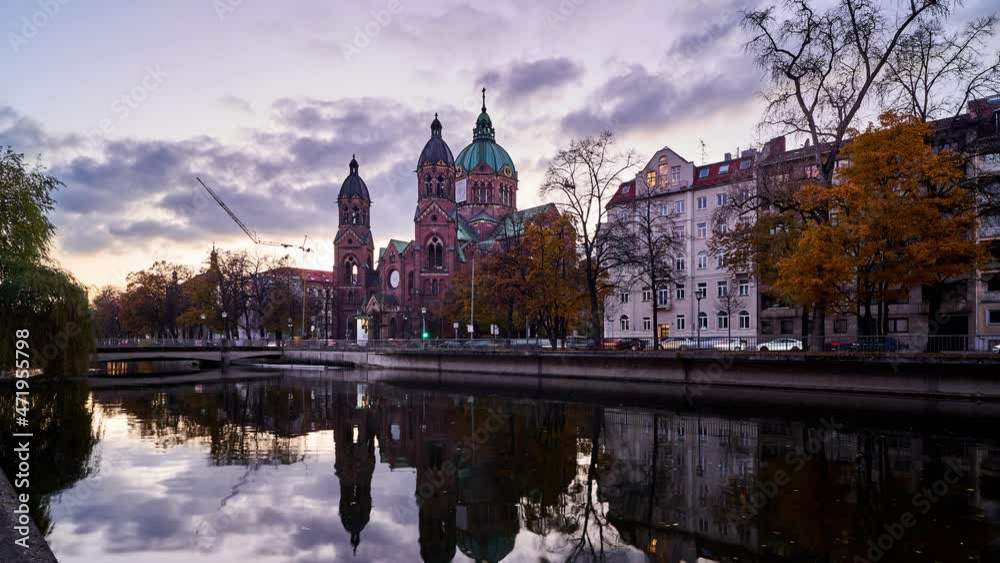 Dusk timelapse of Munich with the historic church of St. Lukas reflecting in the Isar river. Germany