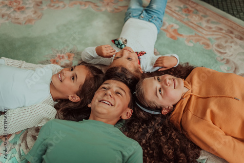 a happy group of friends lie on the floor in a circle of joined heads. Selective focus