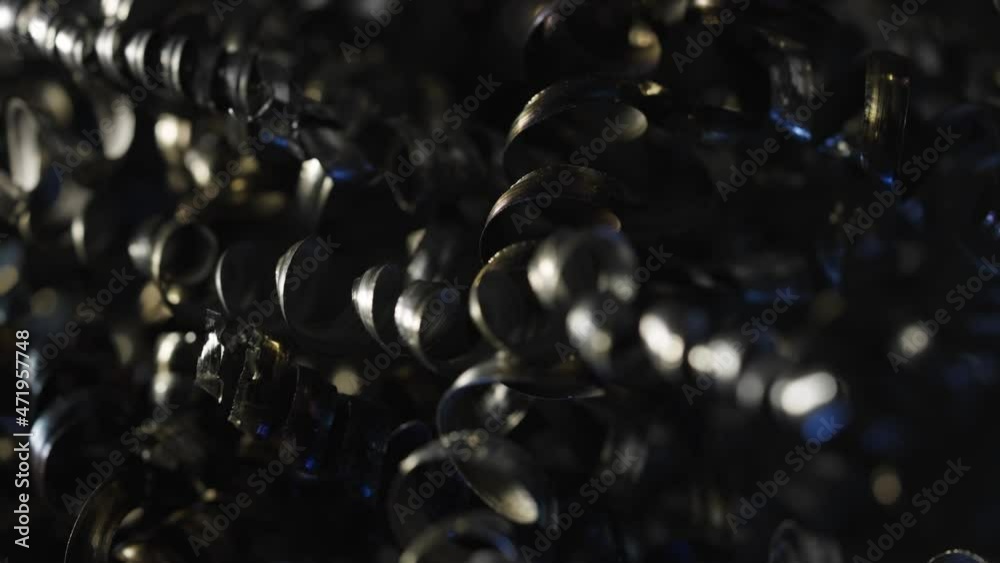 Macro shot of the metal shavings, which can be iron, aluminum or steel. Metal shavings background. Curly metallic spirals, industrial recycling. Close up twisted spiral steel shavings. Slow motion. Macro shot of the metal shavings, which can be iron, aluminum or steel. Metal shavings background. Curly metallic spirals, industrial recycling. Close up twisted spiral steel shavings. Slow motion.