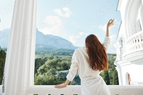 woman looks at a beautiful view from the balcony Perfect sunny morning