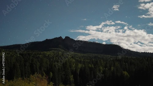 Time Lapse shot of Bootjack mountain in Colorado at night with flying clouds and stars at sky photo