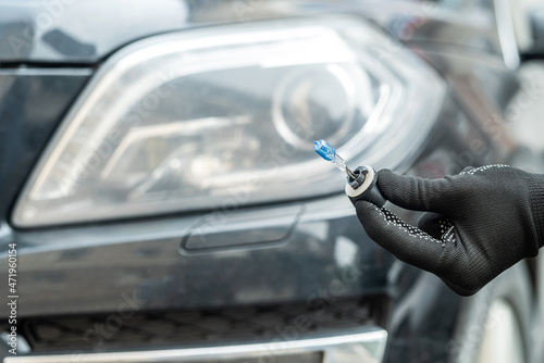 Foto service man replacement halogen car bulb of the front headlight