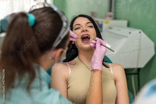 Young woman sitting in dentist chair on doctors review