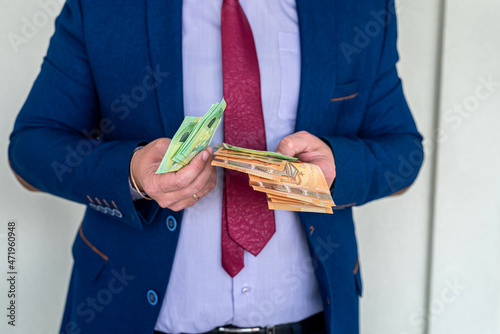 Business man in a suit counts euro banknotes