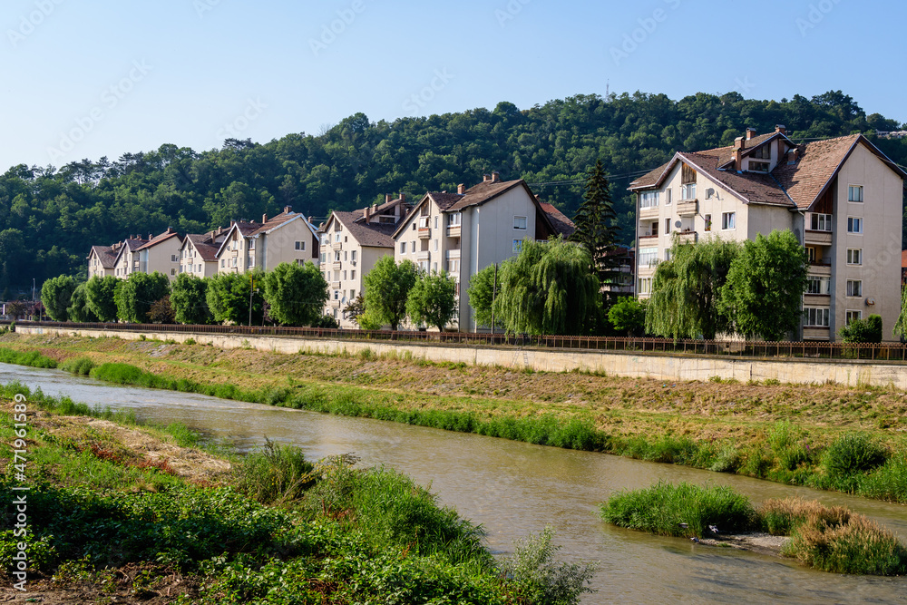 City landscape with Tarnava Mare River and blocks of flats in the center of Sighisoara, in Transylvania (Transilvania) region, Romania, in a sunny summer day.