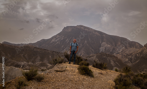 Adult man on Tabernas desert in Almeria, Spain, against cloudy sky