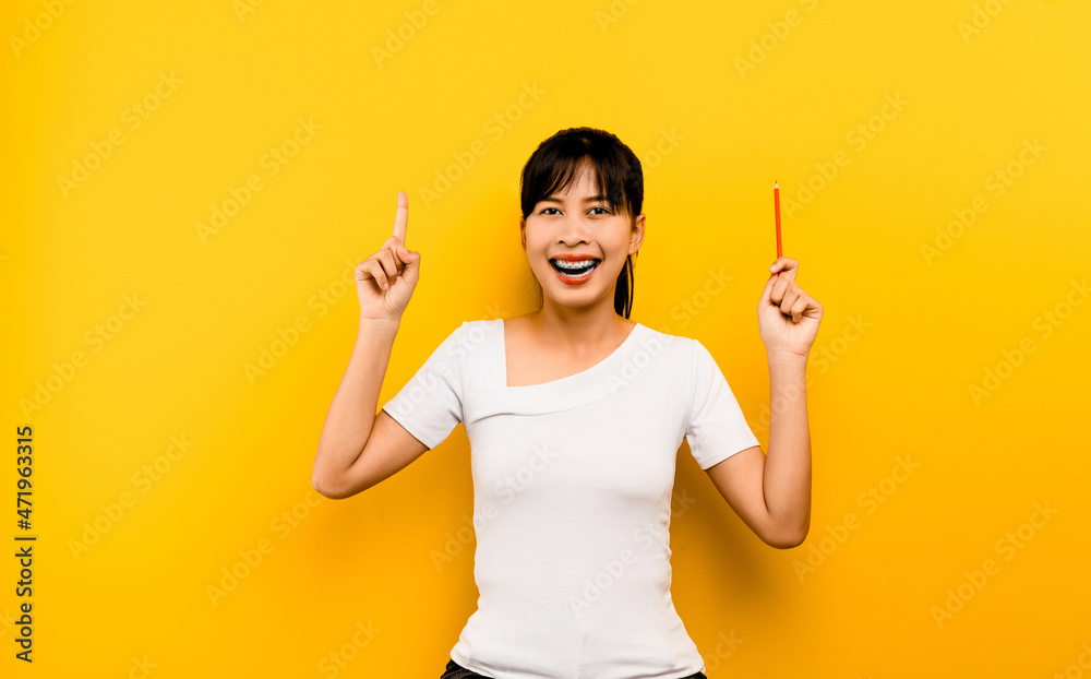 Education and the joy of learning A young Asian woman with a smile and knowledge to study. happiness of ideas on a yellow background educational concept Education and the joy of learning A young Asian woman with a smile and knowledge to study. happiness of ideas on a yellow background educational concept