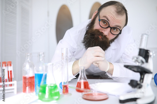 Chemist crazy. A mad scientist conducts experiments in a scientific laboratory. Performs research using a microscope.