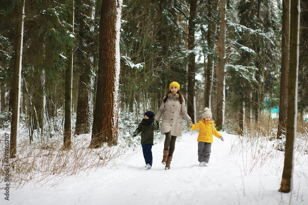 Happy family playing and laughing in winter outdoors in the snow. City park winter day.