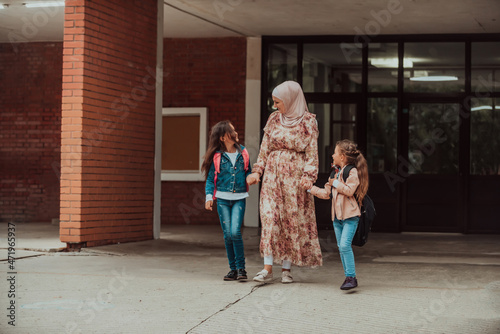 Wallpaper Mural Hijab muslim mother walking her kids to school. Selective focus Torontodigital.ca