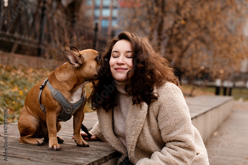 Beautuful young woman and her bulldog kissing photo