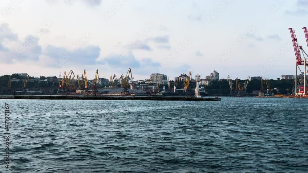 Industrial Harbour Jib Cranes At Port Of Odesa From A Boat Sailing Cruising At Black Sea. - wide shot Industrial Harbour Jib Cranes At Port Of Odesa From A Boat Sailing Cruising At Black Sea. - wide shot