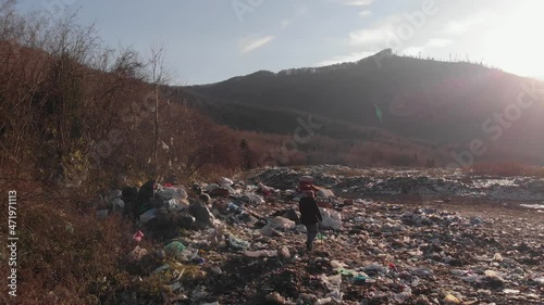 Homeless woman in a junkyard. Garbage dump in the mountains. photo