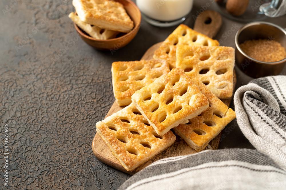 Puff cookies on a serving wooden board on a dark culinary background. Delicious homemade sweet pastries close-up Puff cookies on a serving wooden board on a dark culinary background. Delicious homemade sweet pastries close-up