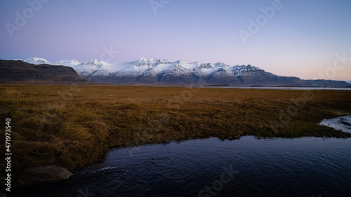 View during sunrise near ring road at Iceland with snowy mountains in the background