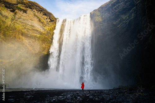 Waterfall and woman under water fall in magical landscape popular Europe attraction.Travelling on Iceland. Skogafoss waterfall and tourist. Famouns place in Iceland. Travel - image