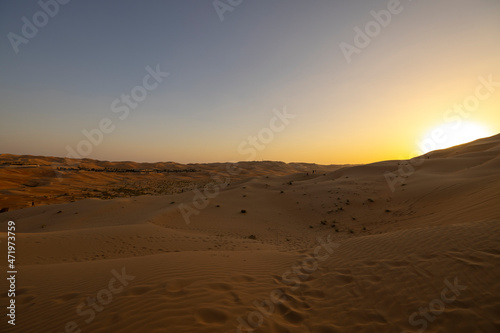 Sunset in the arabian desert with rolling sand dunes in Abu Dhabi, United Arab Emirates