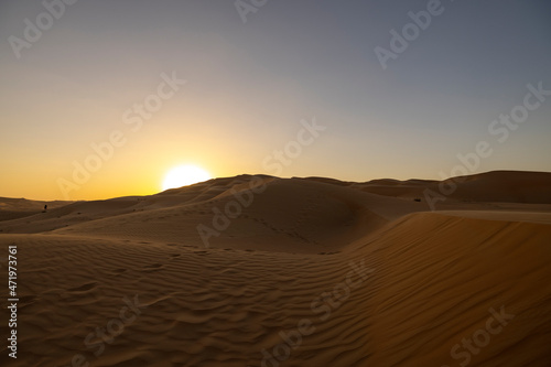 Sunset in the arabian desert with rolling sand dunes in Abu Dhabi, United Arab Emirates
