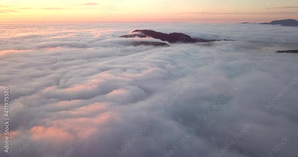 Valderøya and the surrounding sea is covered in unique, fast moving, low level cloud blanket at sunset in winter in Norway. Descending hyper lapse where the camera disappears in the clouds at the end.