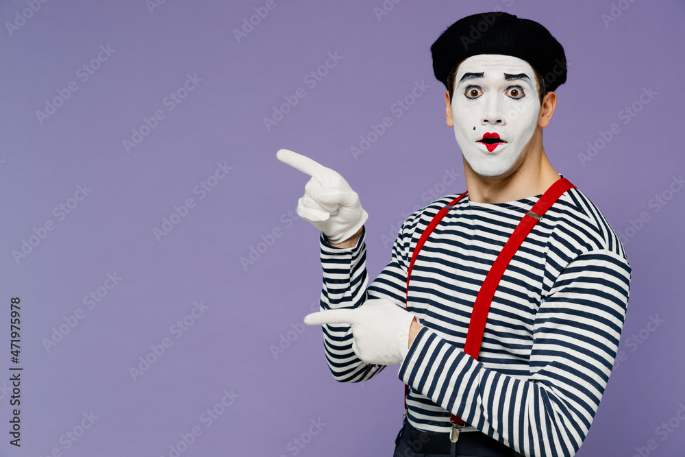 Surprised ecstatic young mime man with white face mask wears striped shirt beret pointing aside on workspace area copy space mock up isolated on plain pastel light violet background studio portrait. Surprised ecstatic young mime man with white face mask wears striped shirt beret pointing aside on workspace area copy space mock up isolated on plain pastel light violet background studio portrait.