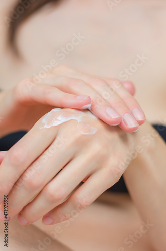 Moisturizer on female hands close-up. A woman applies moisturizer to her hands. Skin care
