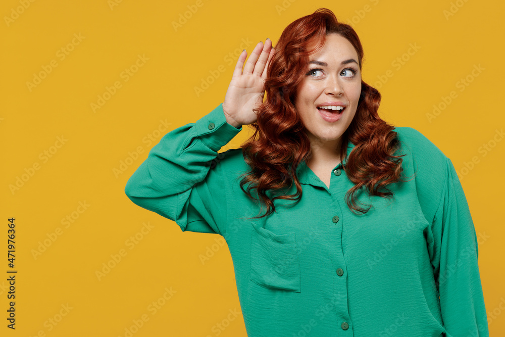 Curious nosy bright fun happy vivid young ginger chubby overweight woman 20s years old wear green shirt try to hear you overhear listening intently isolated on plain yellow background studio portrait Curious nosy bright fun happy vivid young ginger chubby overweight woman 20s years old wear green shirt try to hear you overhear listening intently isolated on plain yellow background studio portrait