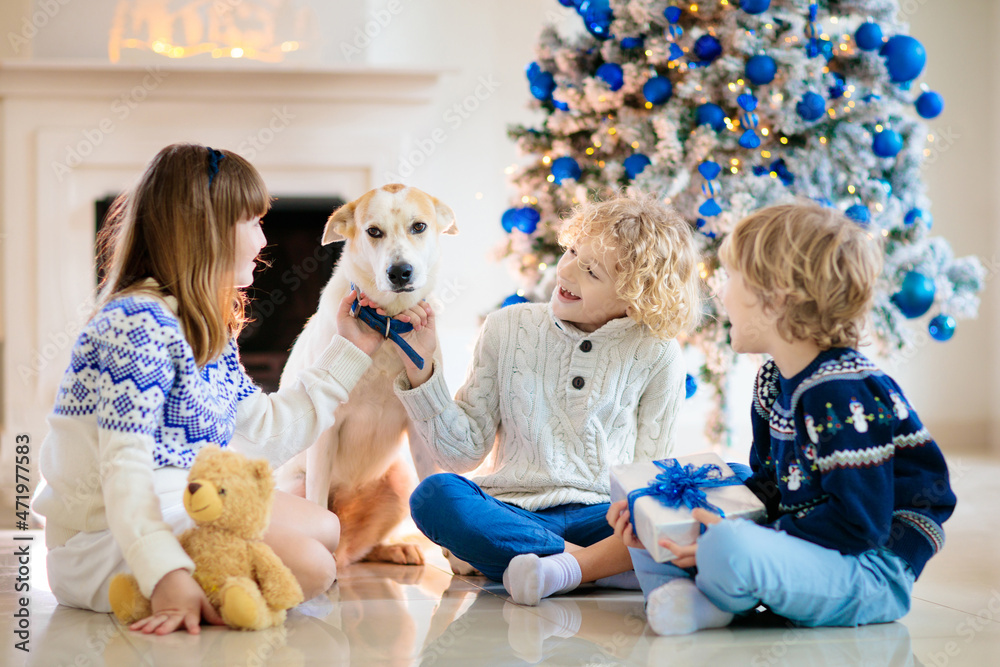 Child at Christmas tree. Kids at fireplace on Xmas Child at Christmas tree. Kids at fireplace on Xmas