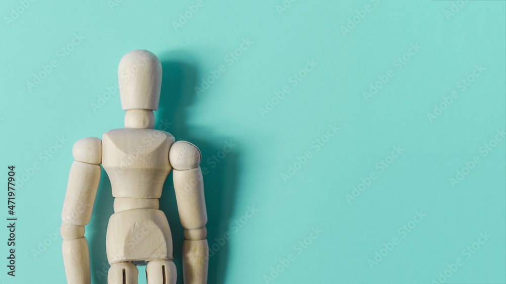 A mannequin of a man made of wood in close-up on a colored background is a place for text. Blank for advertising A mannequin of a man made of wood in close-up on a colored background is a place for text. Blank for advertising